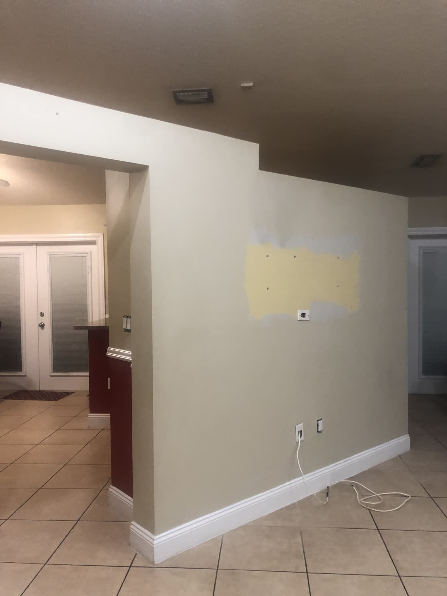 Cocina tipo pasillo oscura y anticuada con gabinetes rojizos antes de una remodelación de casa completa en Country Walk, Miami