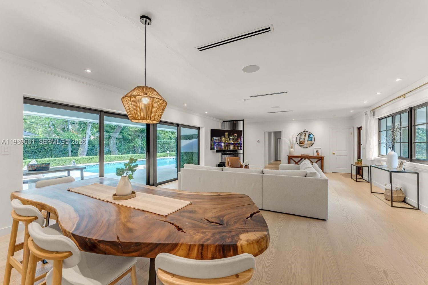Gallery-white living space with wide-plank wood floors in a completed Miami-Dade residential renovation