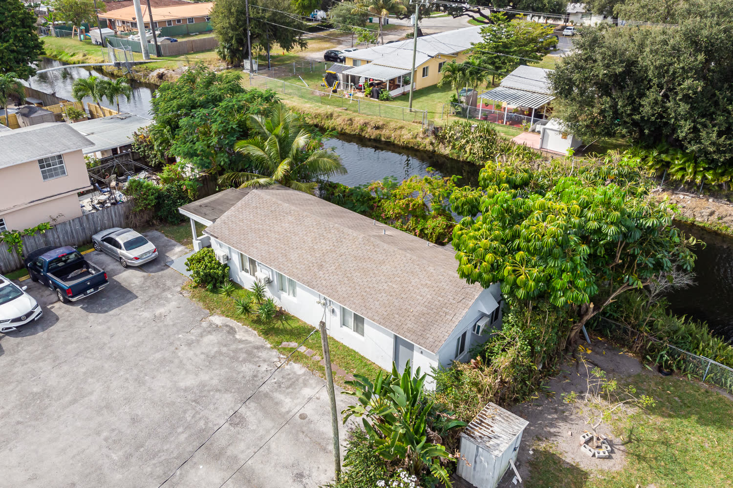 Canal-side multi-family building exterior in West Miami renovated under permit by a licensed general contractor
