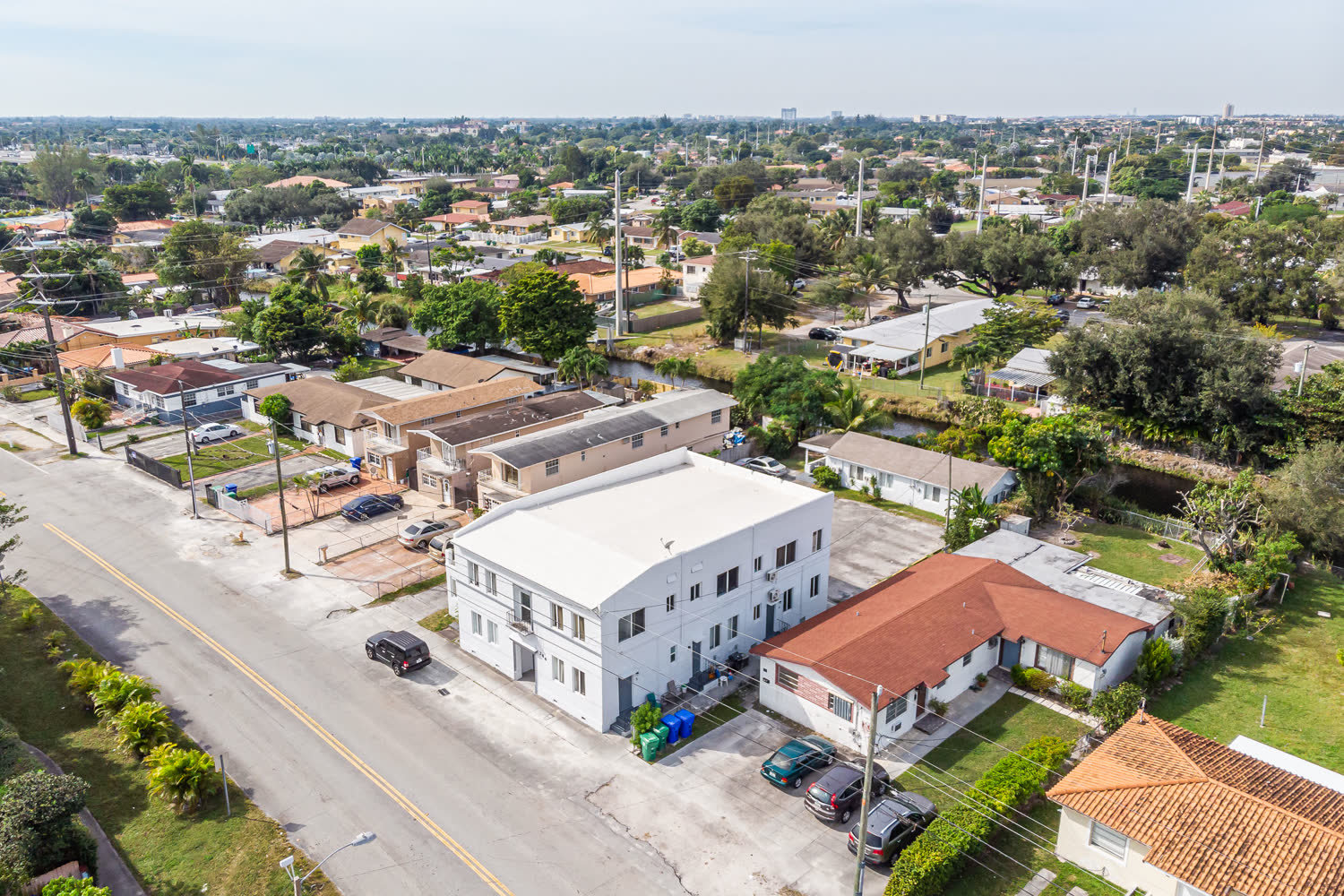 Canal-front multi-family building exterior in West Miami where flood zone designation affects renovation scope