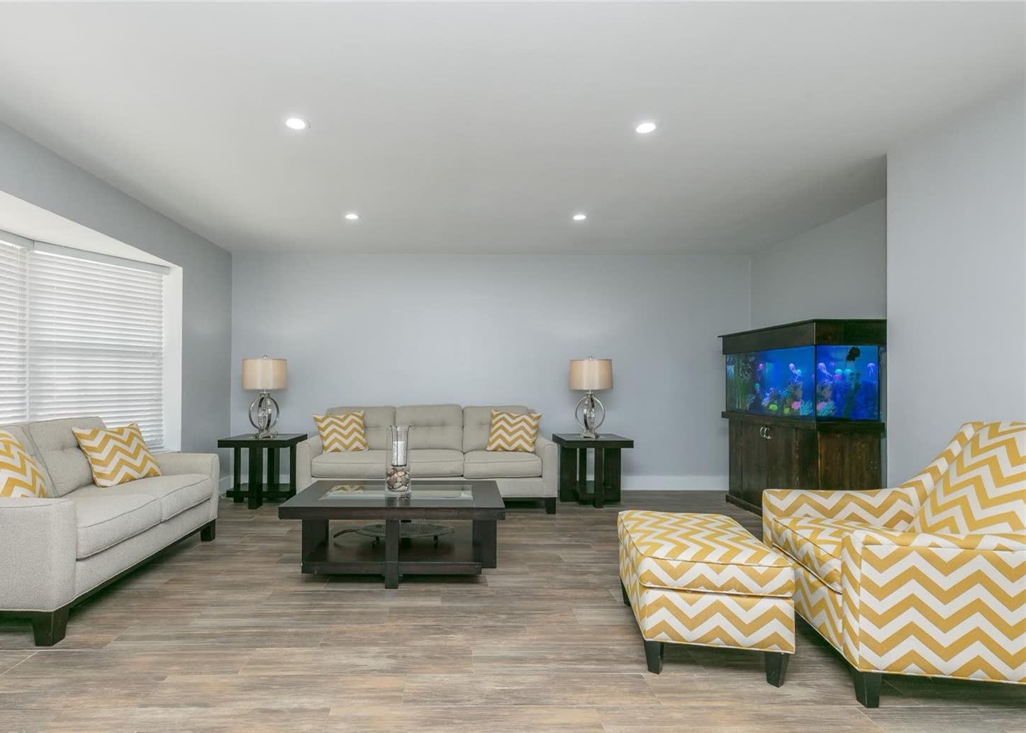 Sala renovada, luminosa y neutra, con piso nuevo tipo tablón en una renovación value-add en Westchester